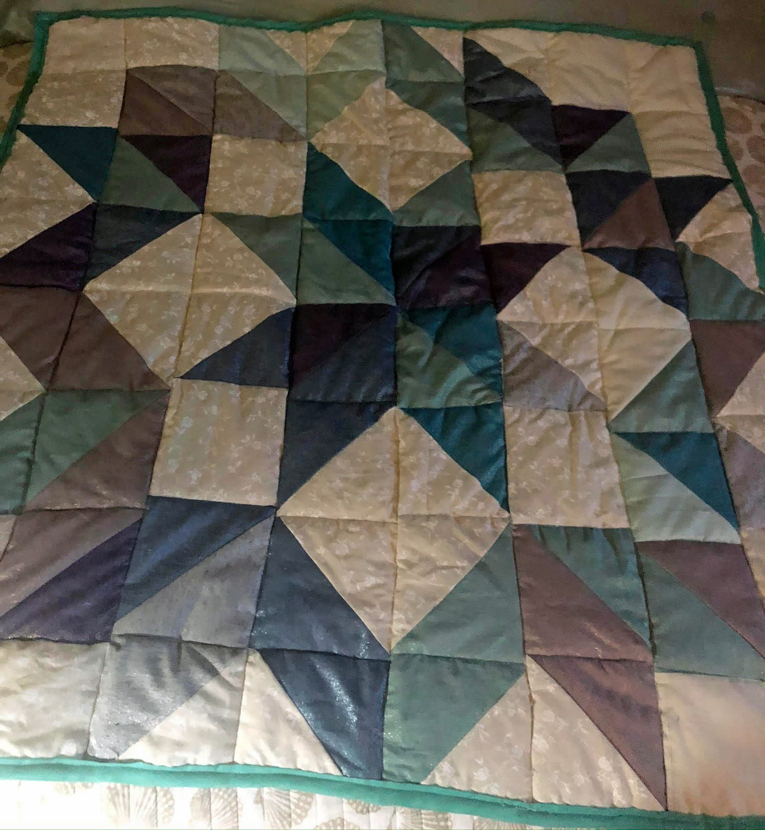 A patterned quilt featuring blue and green