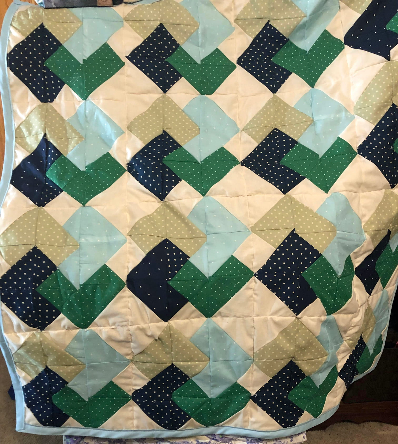 A patterned quilt featuring a green and blue pattern