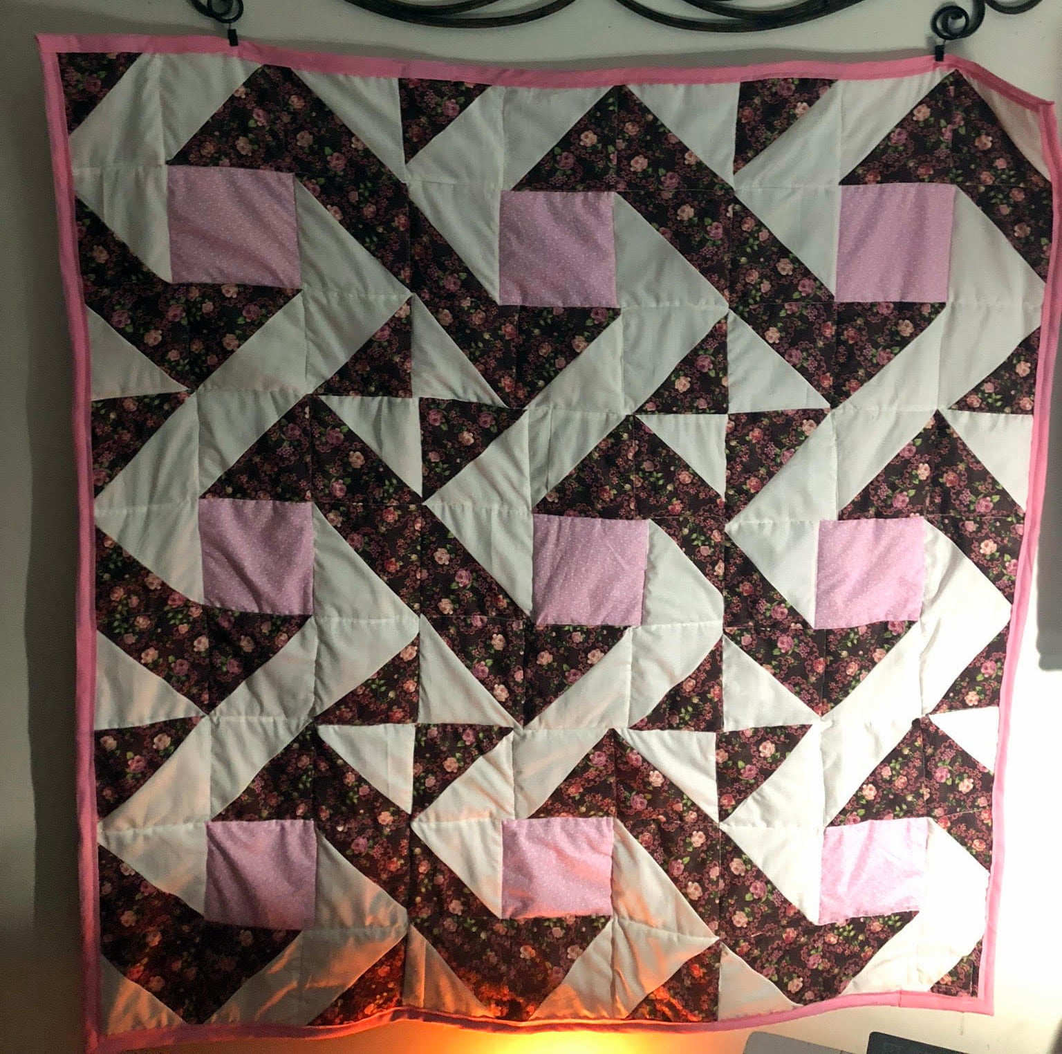A patterned quilt featuring pink and flowers
